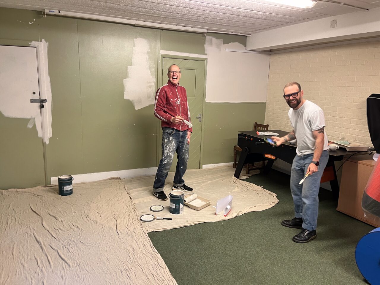 Matt and Marc from HVA laughing whilst they help paint the green room at the Hastings Y-Centre